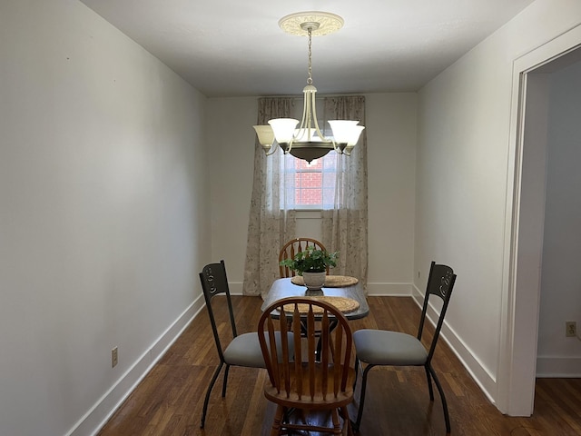 dining area with dark hardwood / wood-style floors and an inviting chandelier