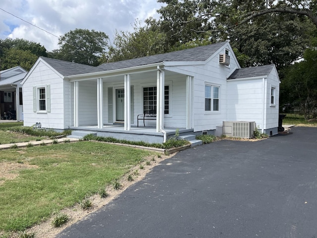 view of front of house featuring a porch, a front yard, and central air condition unit