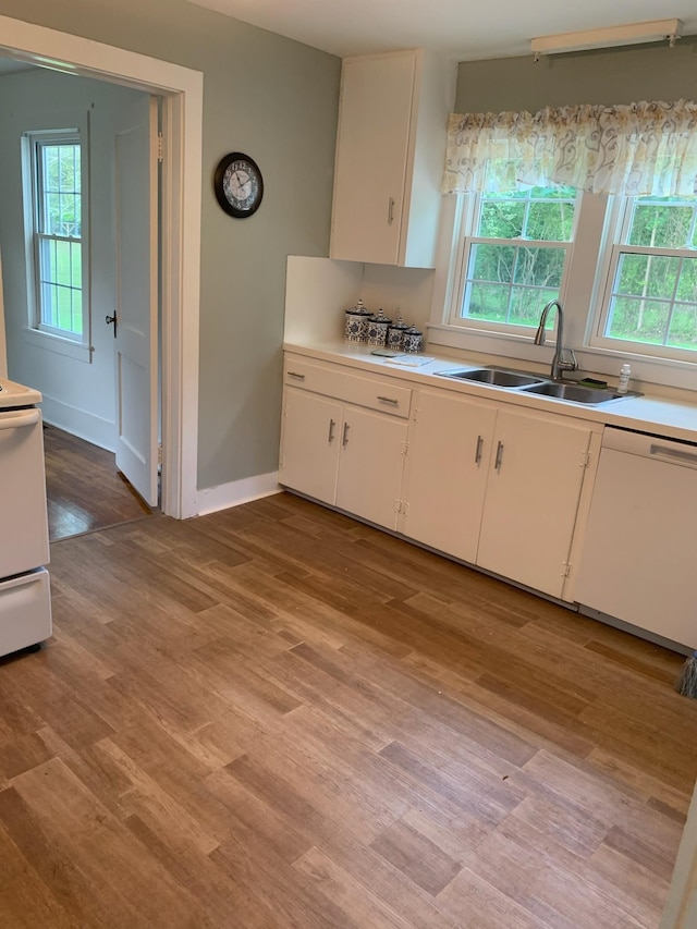 kitchen featuring white cabinetry, sink, white appliances, and a healthy amount of sunlight