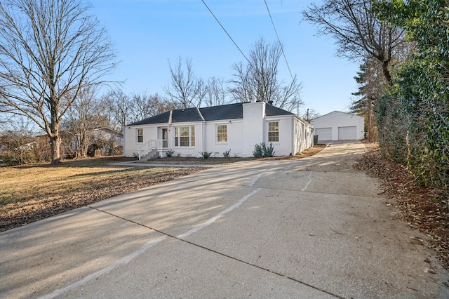 ranch-style home with a garage and an outbuilding