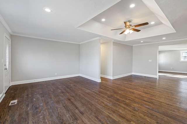 unfurnished room featuring dark hardwood / wood-style flooring, crown molding, a raised ceiling, and ceiling fan