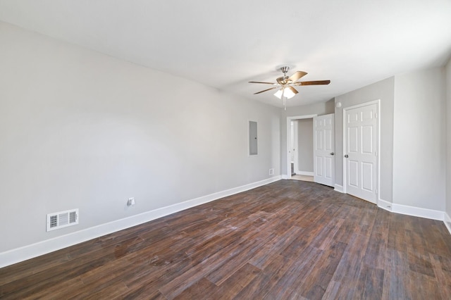 empty room with dark wood-type flooring, ceiling fan, and electric panel