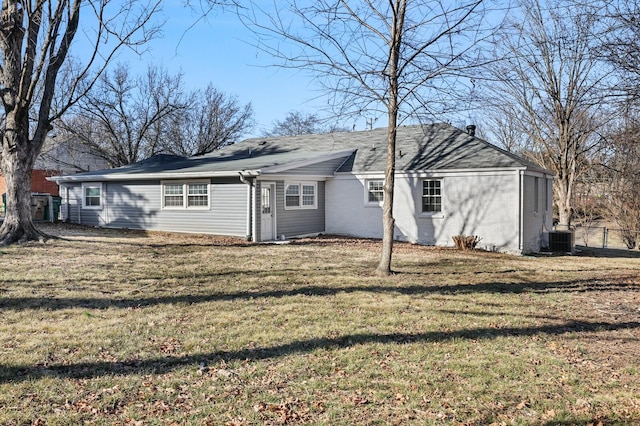 rear view of property featuring a yard and central AC