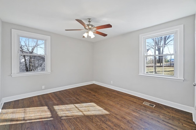 unfurnished room featuring dark hardwood / wood-style floors, a wealth of natural light, and ceiling fan