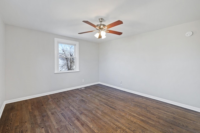 spare room featuring dark wood-type flooring and ceiling fan