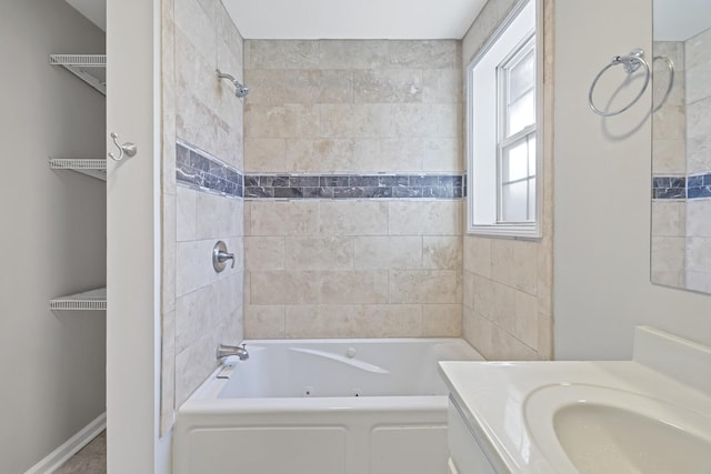 bathroom featuring tiled shower / bath and vanity