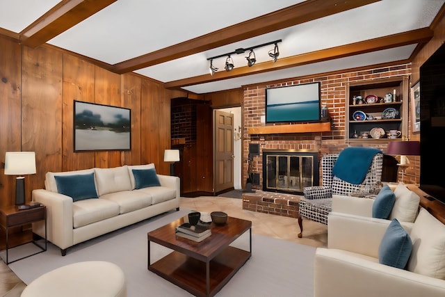 living room with built in shelves, beam ceiling, light tile patterned floors, wooden walls, and a fireplace