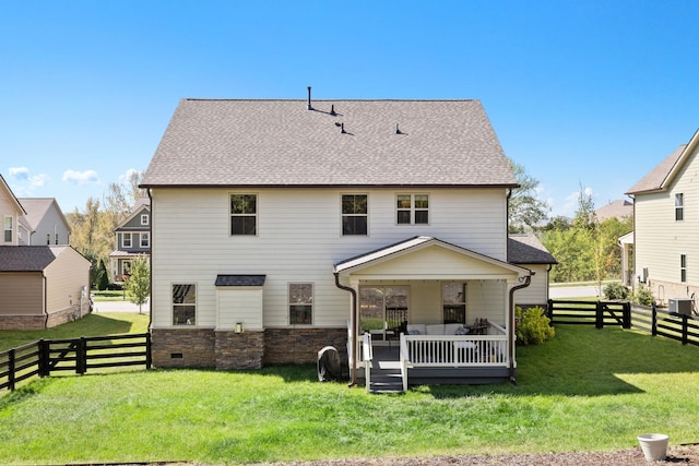 rear view of house featuring a deck and a lawn