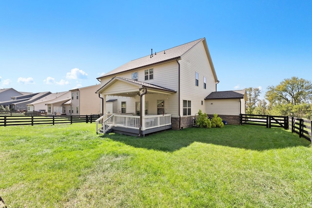 back of property with a yard and a deck