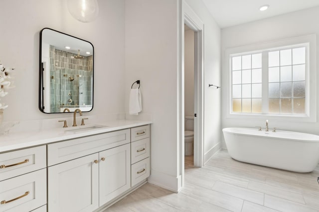 full bathroom featuring vanity, shower with separate bathtub, and toilet