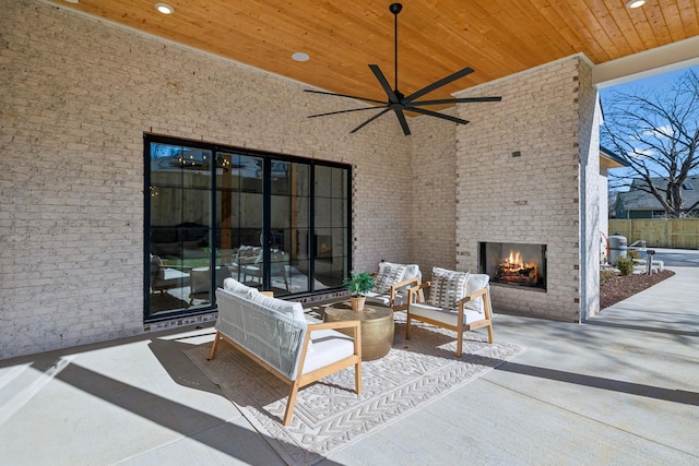 view of patio / terrace with an outdoor brick fireplace and ceiling fan