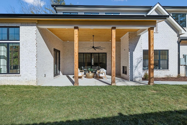 rear view of property featuring an outdoor living space, a patio, ceiling fan, and a lawn