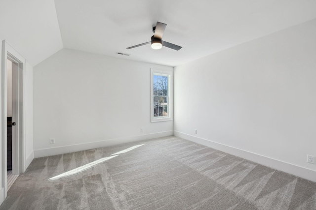 empty room with ceiling fan, lofted ceiling, and light carpet