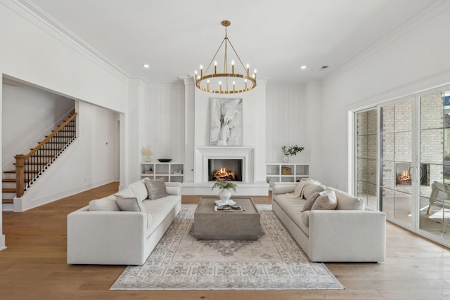 living room featuring crown molding, a notable chandelier, and light hardwood / wood-style floors