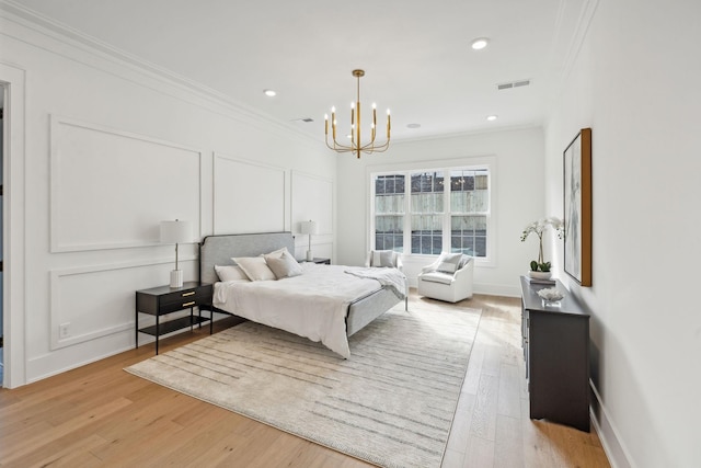 bedroom with light hardwood / wood-style flooring, ornamental molding, and a chandelier