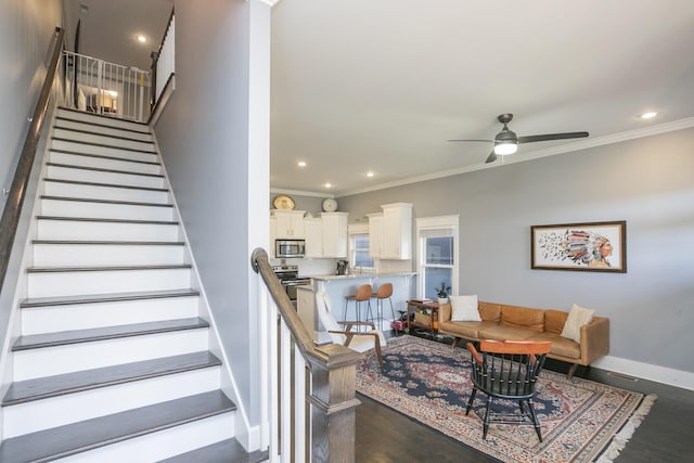 staircase featuring crown molding, wood-type flooring, and ceiling fan