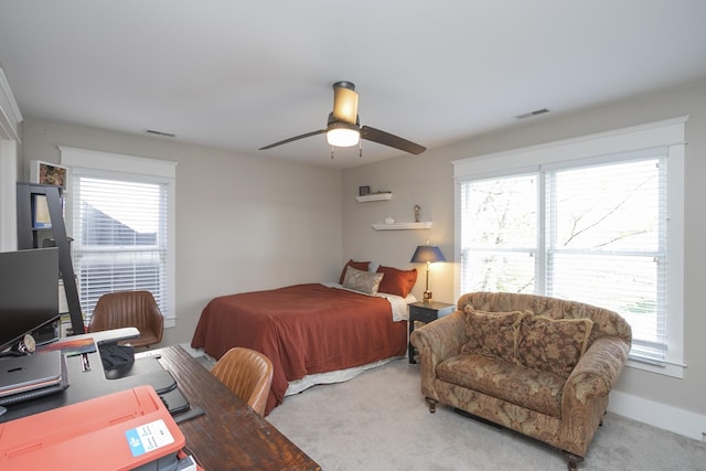 carpeted bedroom featuring multiple windows and ceiling fan