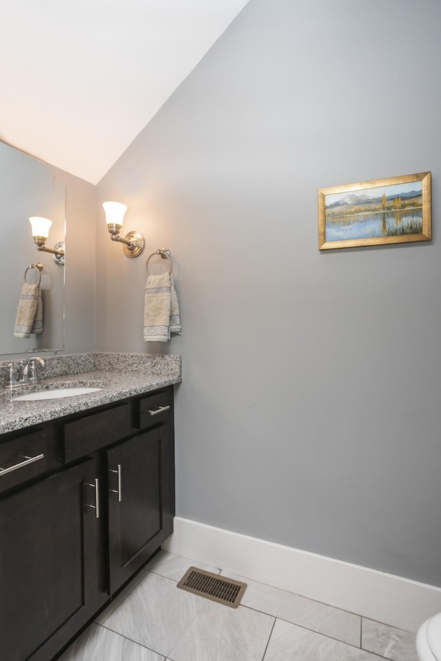 bathroom with lofted ceiling and vanity