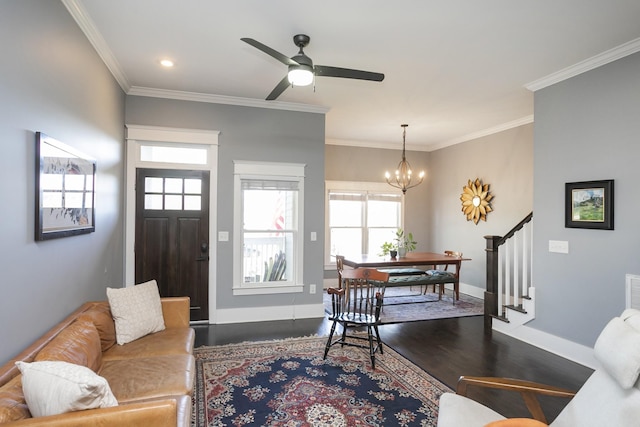 living room featuring crown molding, ceiling fan with notable chandelier, and dark wood-type flooring