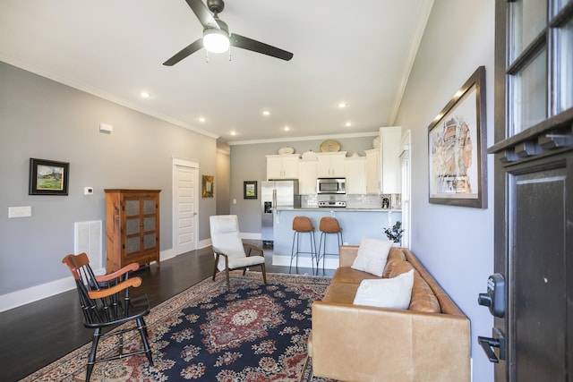 living room with hardwood / wood-style floors, ornamental molding, and ceiling fan