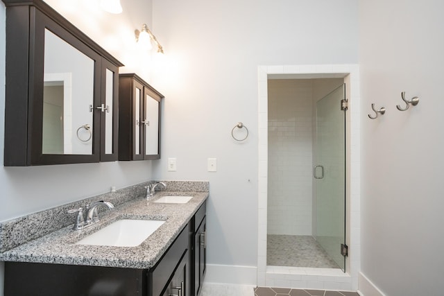 bathroom featuring tile patterned flooring, vanity, and a shower with door