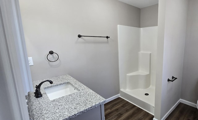 bathroom with wood-type flooring, vanity, and walk in shower