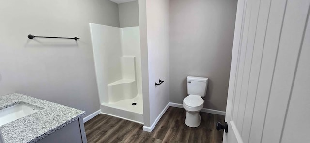 bathroom featuring vanity, wood-type flooring, a shower, and toilet