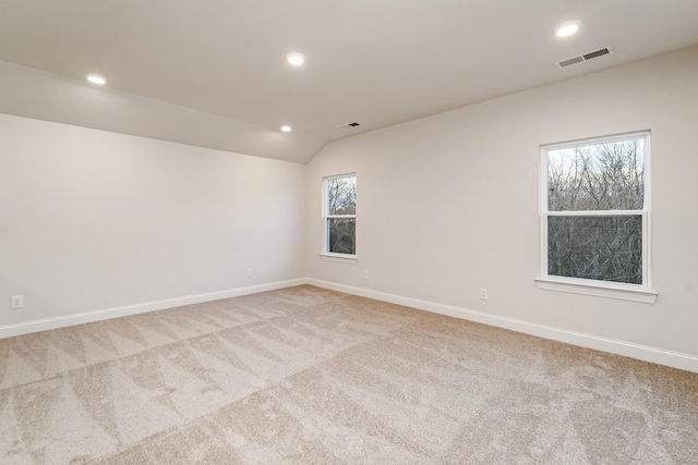 unfurnished room with light carpet, baseboards, visible vents, vaulted ceiling, and recessed lighting