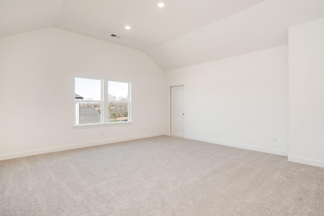 empty room featuring baseboards, visible vents, light colored carpet, lofted ceiling, and recessed lighting