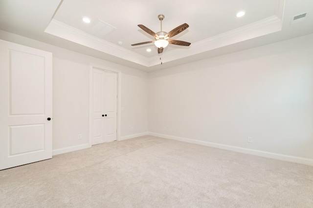 spare room featuring ornamental molding, a tray ceiling, and baseboards