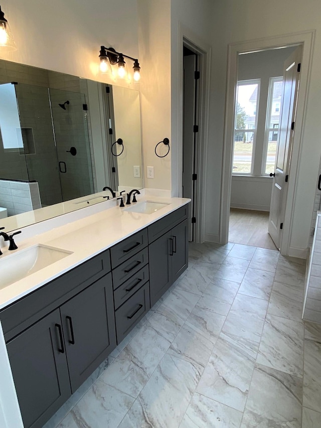 full bathroom featuring double vanity, marble finish floor, a sink, and a stall shower