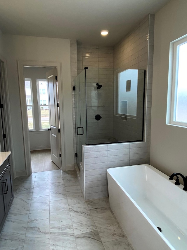 bathroom with marble finish floor, a stall shower, a soaking tub, and vanity