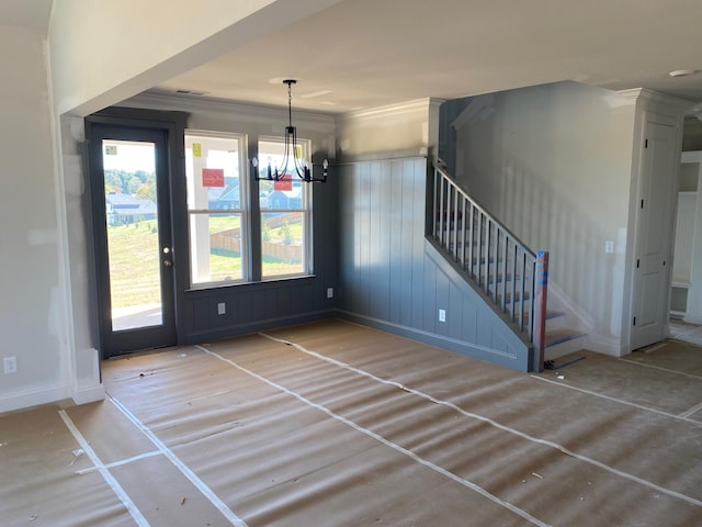 unfurnished dining area with an inviting chandelier and crown molding