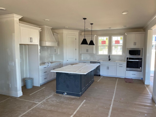 kitchen with appliances with stainless steel finishes, sink, a kitchen island, and white cabinets