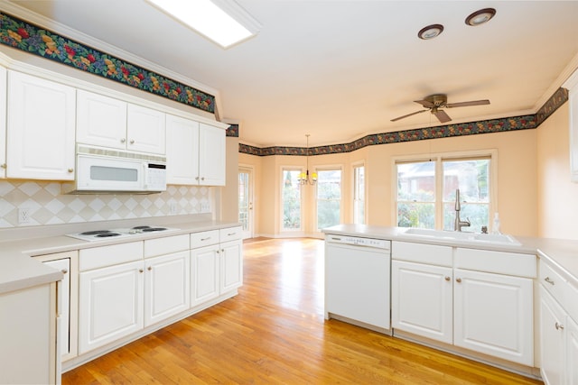 kitchen with pendant lighting, sink, white appliances, tasteful backsplash, and white cabinets