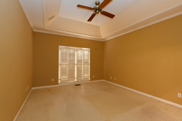 unfurnished room featuring a tray ceiling, carpet floors, ornamental molding, and ceiling fan