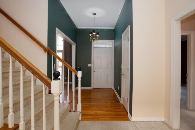 entrance foyer with crown molding, hardwood / wood-style floors, and a notable chandelier