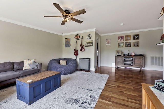 living room featuring crown molding, dark wood-type flooring, and ceiling fan