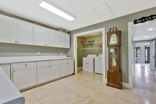 kitchen with white cabinetry, washing machine and clothes dryer, and light tile patterned flooring