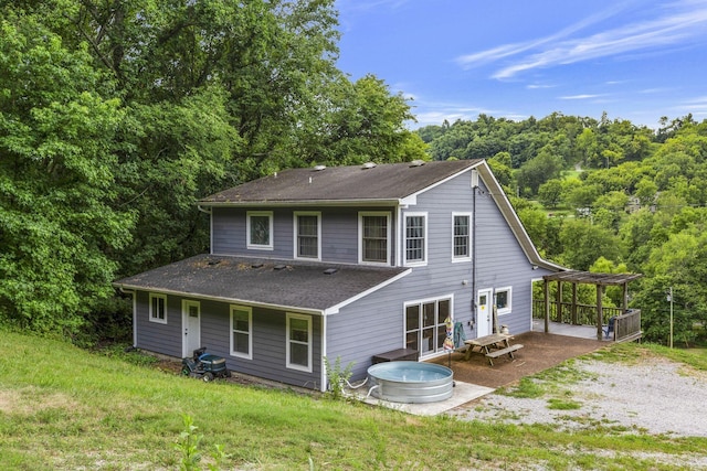 rear view of house featuring a patio and a lawn