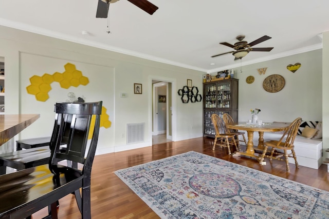 dining room featuring hardwood / wood-style flooring, crown molding, and ceiling fan