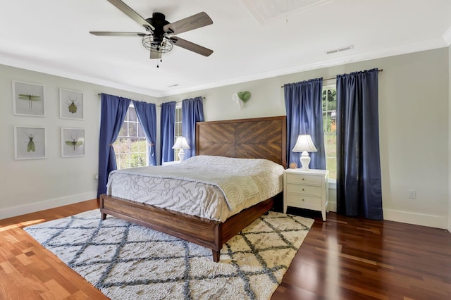 bedroom featuring multiple windows, ornamental molding, dark wood-type flooring, and ceiling fan