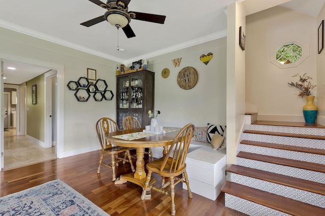 dining space featuring crown molding, dark wood-type flooring, and ceiling fan