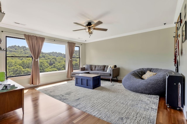 living room featuring hardwood / wood-style floors, ornamental molding, and ceiling fan