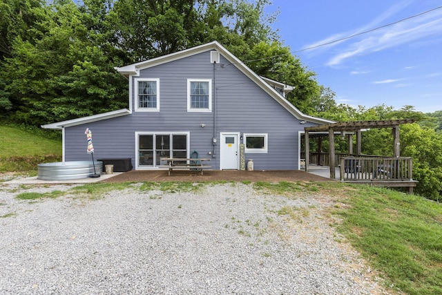 back of property with a wooden deck and a pergola