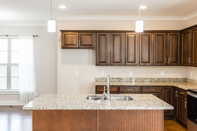 kitchen with sink, hanging light fixtures, light stone countertops, and a center island