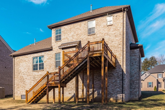 back of property featuring a wooden deck and a yard