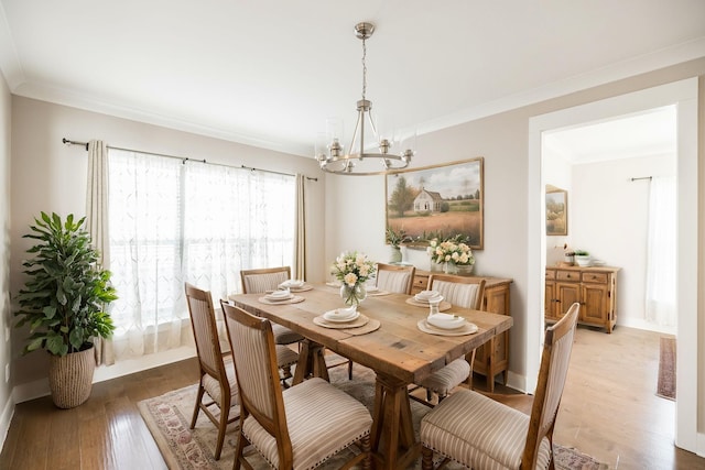 dining area with crown molding, a notable chandelier, and hardwood / wood-style flooring