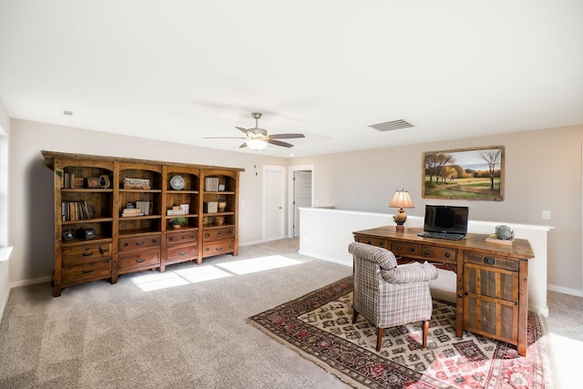 carpeted office space featuring ceiling fan