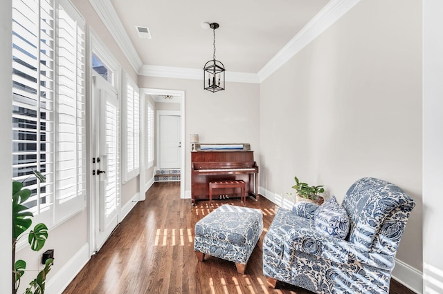 sitting room with crown molding, a notable chandelier, dark hardwood / wood-style flooring, and french doors